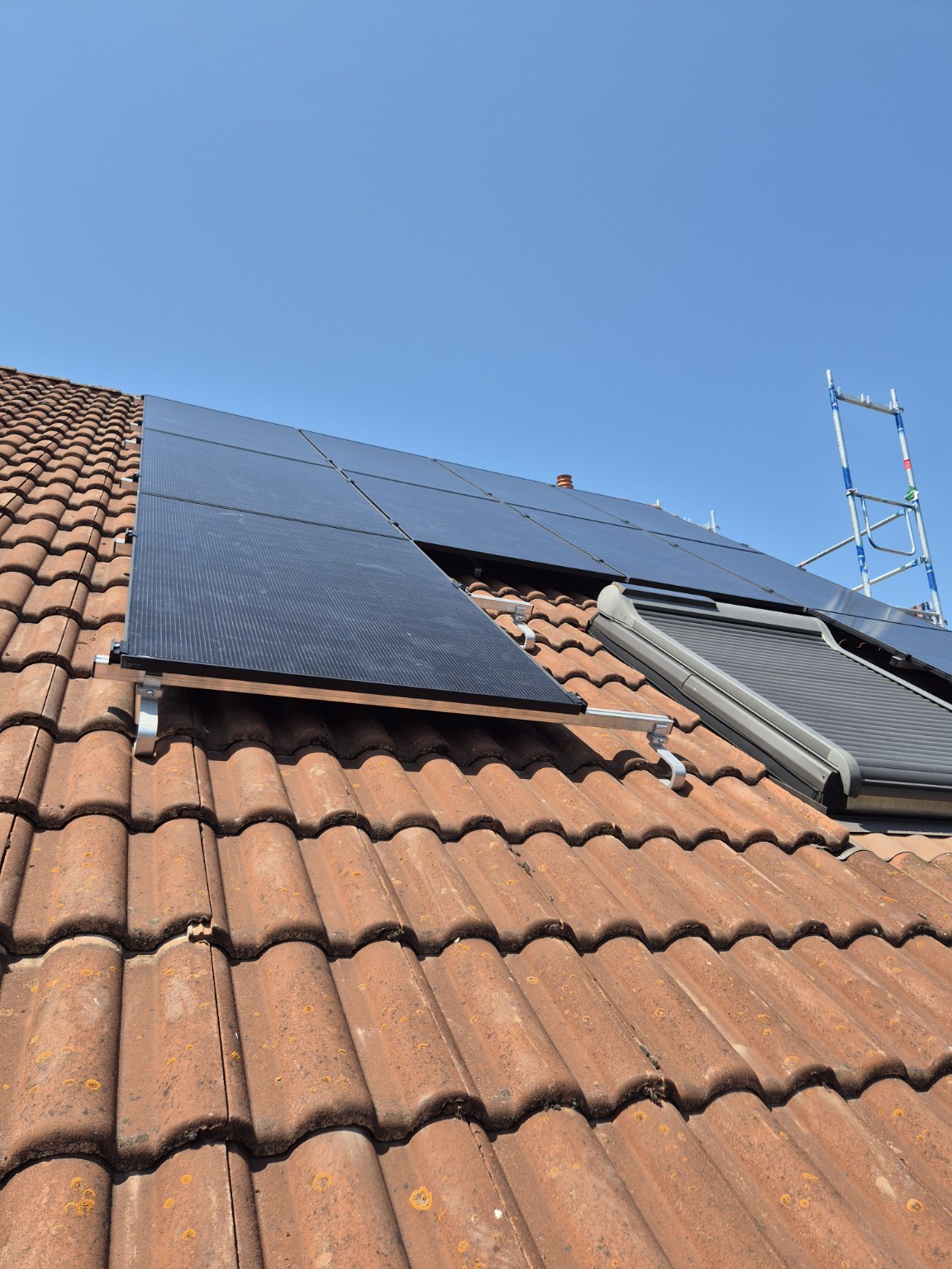 Photovoltaik-Module auf dem Ziegeldach, im Hintergrund ein Gerüst für die Montage, Projekt Dortmund
